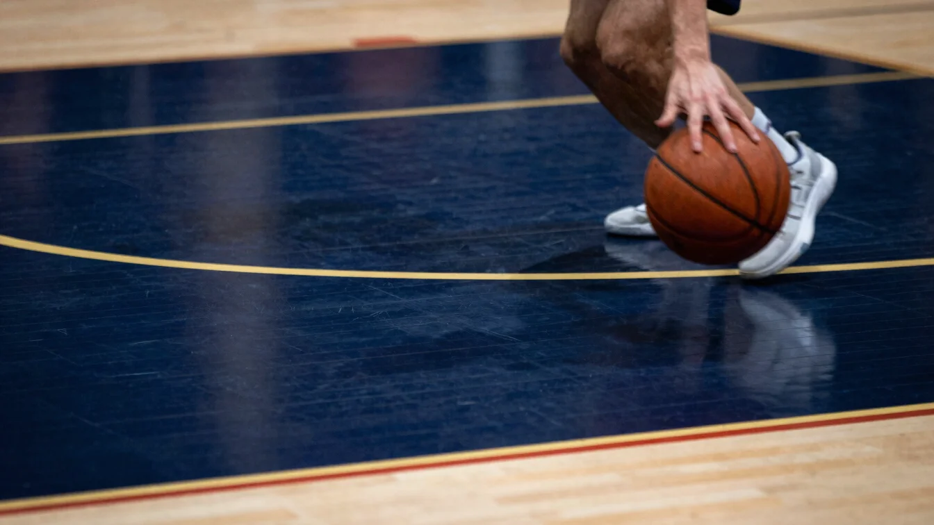 Close-up of a basketball player's hand dribbling the ball, motion